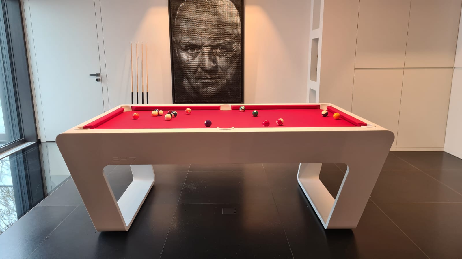 White 724 billiard table with a red playing surface in a modern private villa interior.
