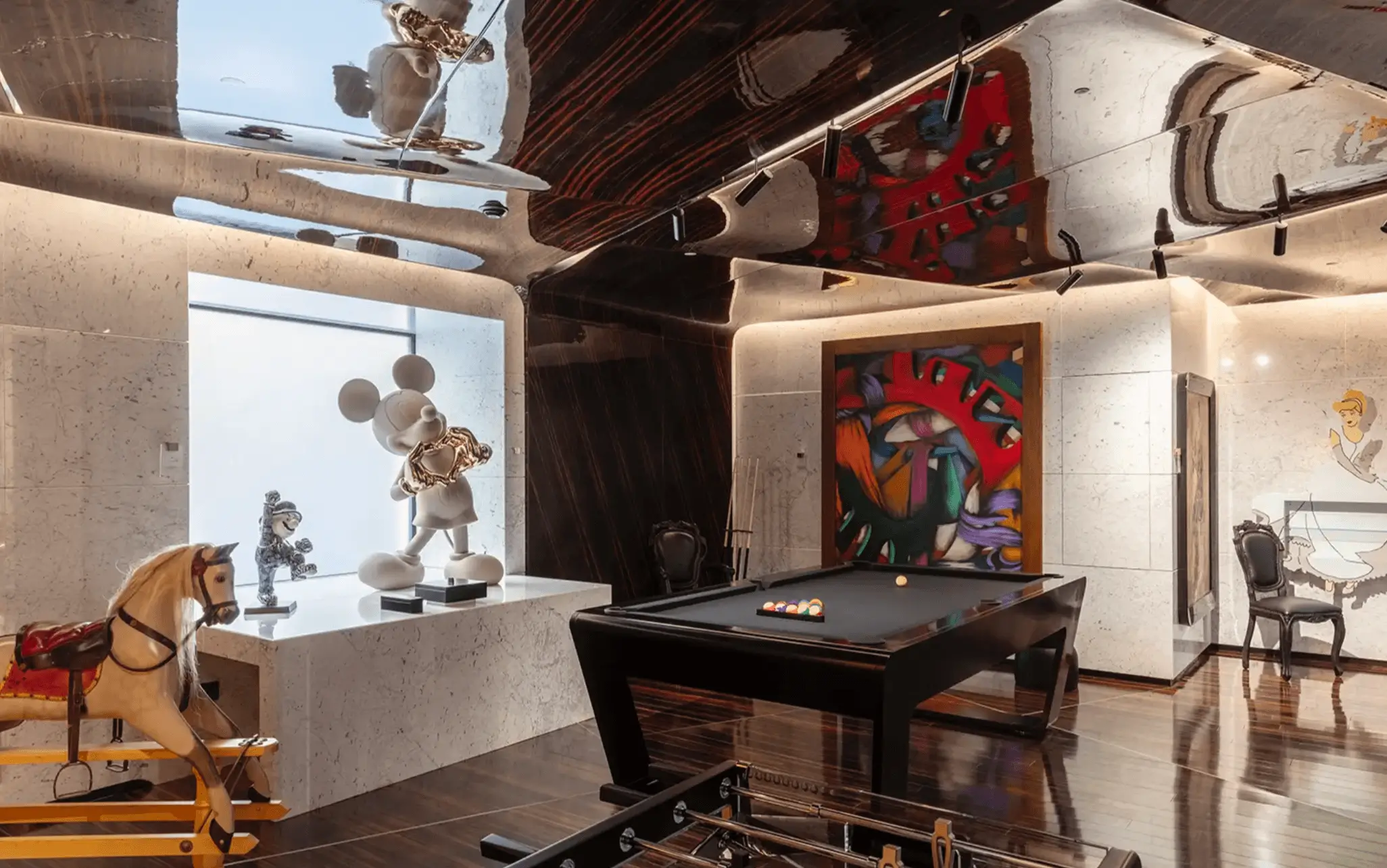 Black luxury pool table in an artistic interior with colorful artwork and decorative sculptures.