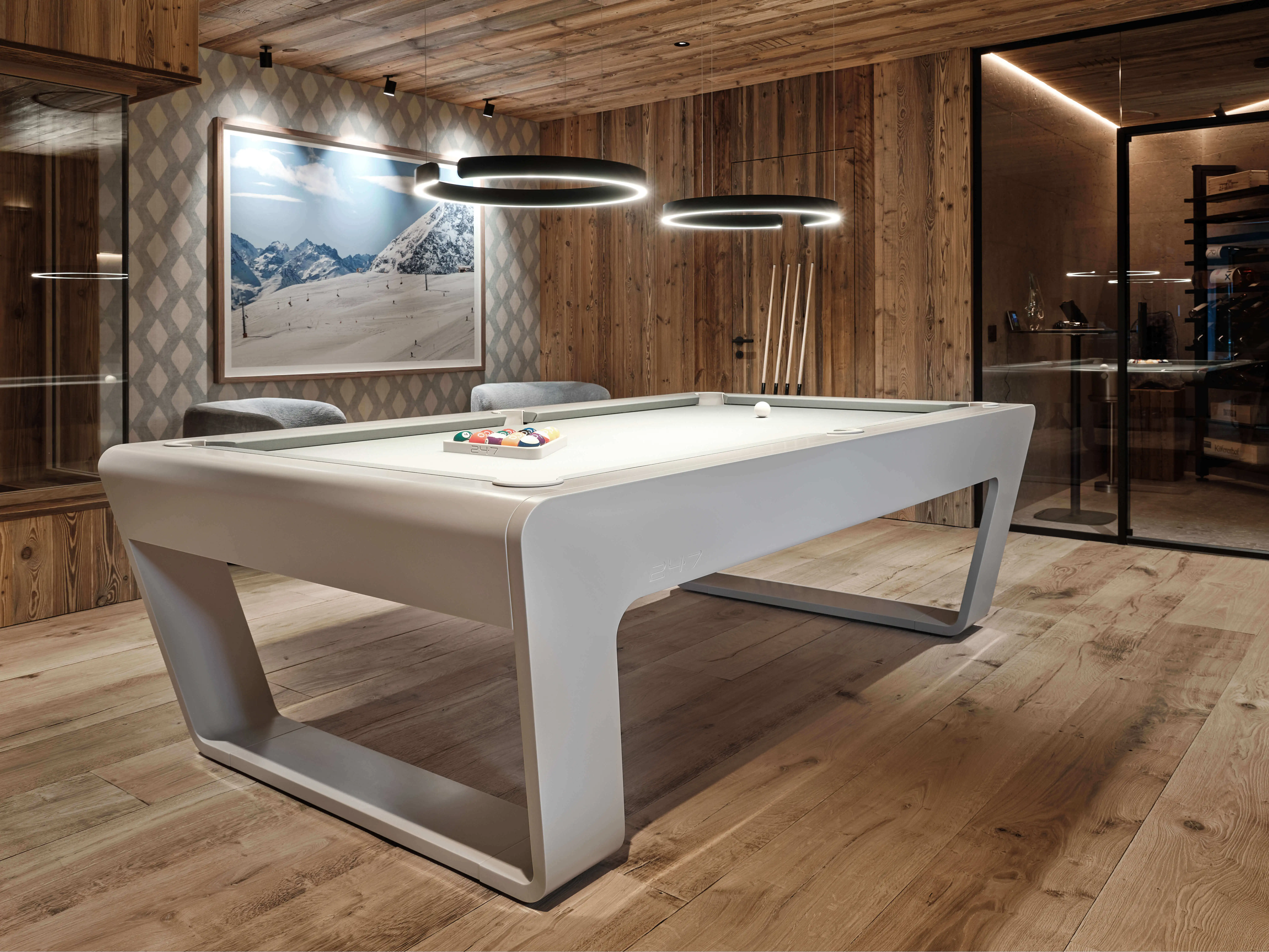 White luxury pool table with billiard balls in a rustic wooden interior.
