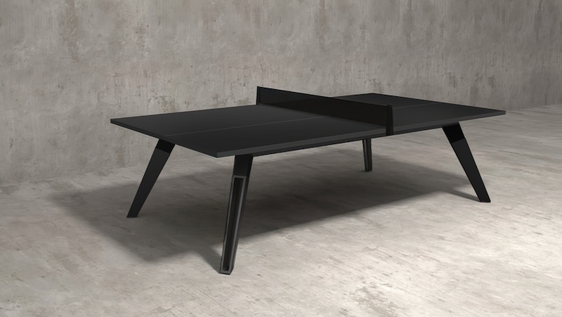 Modern black table tennis table with a black net and angled legs in a minimalist concrete interior.