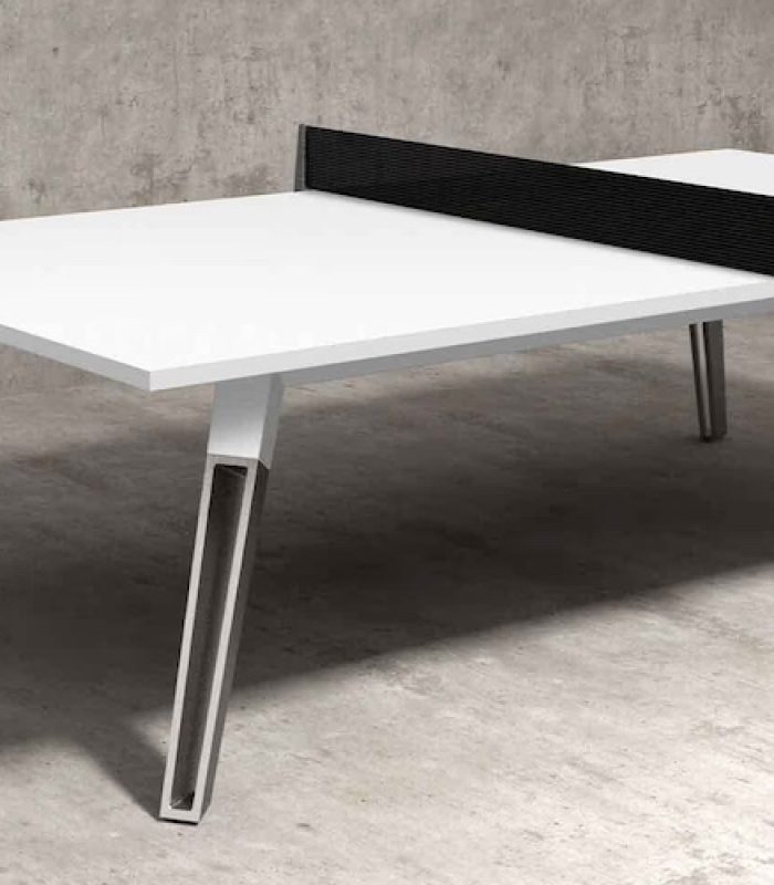 Modern white table tennis table with a black net in a minimalist concrete interior.